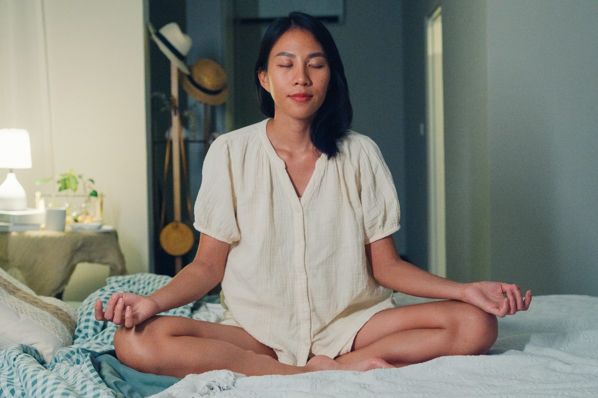 woman meditating at night before sleeping