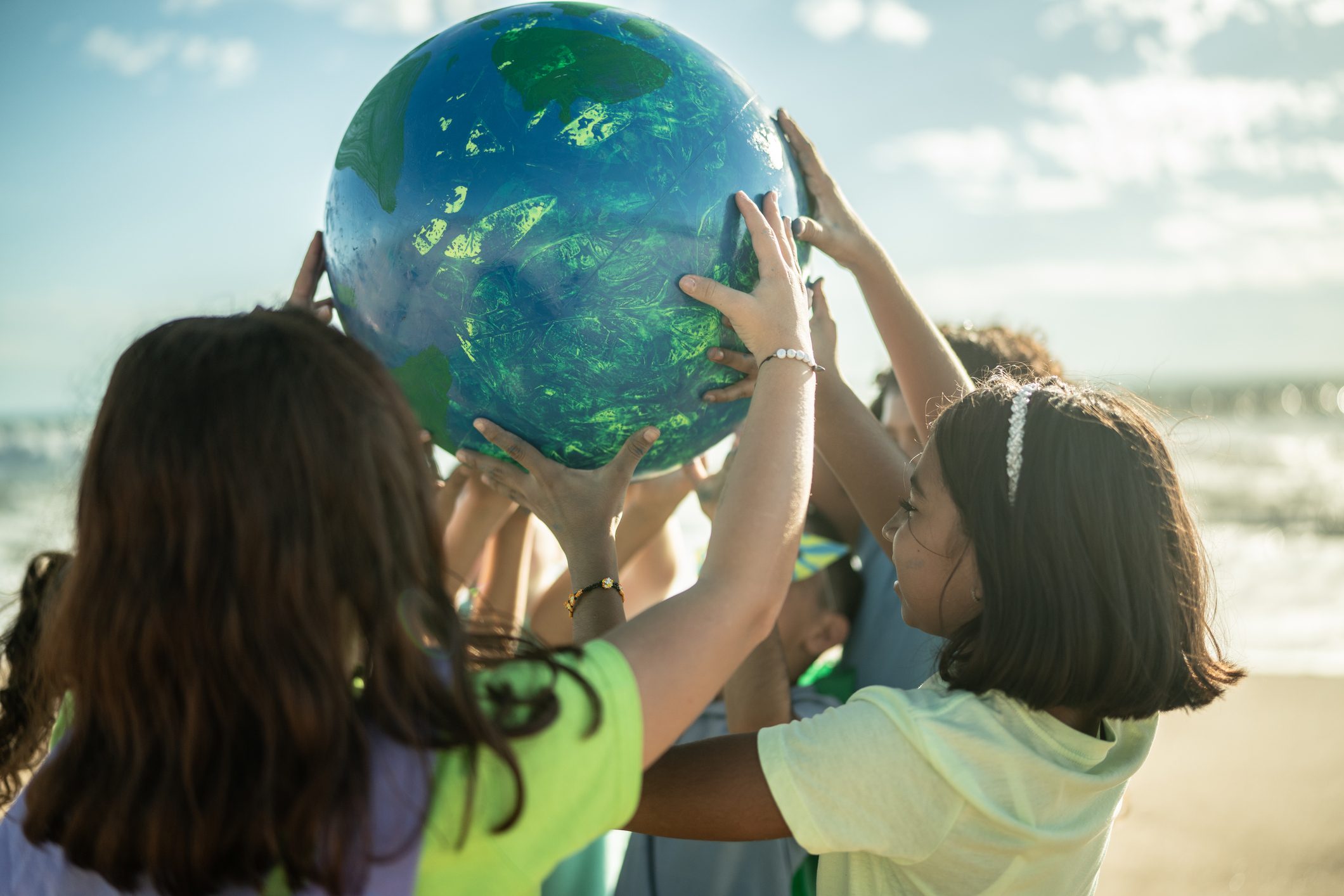 Children Holding A Planet At The Beach