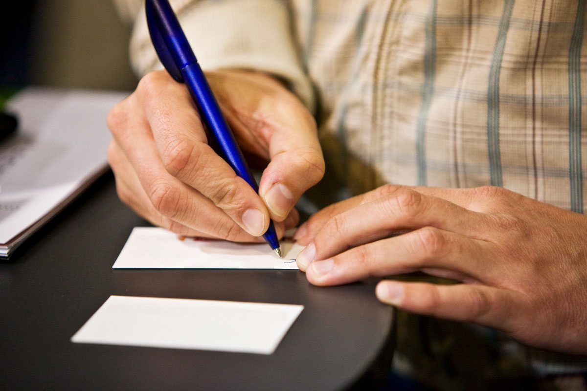 Man Writing On Business Card